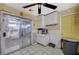 The kitchen features a sliding door, ceiling fan and a yellow door and some cabinets at 405 Longtree Ave, Henderson, NV 89011