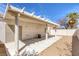 Spacious covered patio with desert landscaping and white privacy fence at 4828 Marco Polo St, North Las Vegas, NV 89031