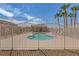 Community pool area featuring palm trees, an ornate metal fence, multiple lounge chairs, and desert landscaping at 4828 Marco Polo St, North Las Vegas, NV 89031
