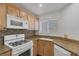 Cozy kitchen with granite countertops, tiled backsplash, wooden cabinets, and modern white appliances at 4828 Marco Polo St, North Las Vegas, NV 89031