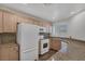 Functional kitchen featuring wood cabinets, granite counters, modern appliances, and new flooring at 4828 Marco Polo St, North Las Vegas, NV 89031