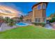 Expansive backyard features lush green lawn, custom pool and spa, and covered patio for entertaining at 5 Via Ravenna Ct, Henderson, NV 89011