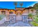 Elegant two-story home featuring stone pillars, iron gate, palm trees, and manicured landscaping at 5 Via Ravenna Ct, Henderson, NV 89011
