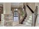 Elegant foyer featuring a grand staircase, stone accents, and arched doorway with decorative iron doors at 5 Via Ravenna Ct, Henderson, NV 89011