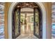 Elegant home foyer featuring iron doors, stone archway, tile flooring, and grand entryway at 5 Via Ravenna Ct, Henderson, NV 89011