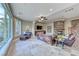Cozy living room with a stone fireplace, comfortable leather seating, and expansive windows at 5 Via Ravenna Ct, Henderson, NV 89011