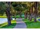Picturesque walking path winding alongside a tranquil lake with mature trees and lush greenery at 5 Via Ravenna Ct, Henderson, NV 89011