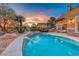 Stunning backyard with a sparkling pool and spa, a water feature, and an outdoor kitchen with seating area at 5 Via Ravenna Ct, Henderson, NV 89011