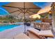 Inviting outdoor living with a sparkling pool, jacuzzi, tanning deck, and built-in BBQ at sunset at 5 Via Ravenna Ct, Henderson, NV 89011