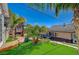 Landscaped backyard with mature palm trees, artificial turf, and outdoor living space at 516 Arizona St, Boulder City, NV 89005