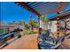 Backyard with multiple areas featuring a pergola, fireplace, outdoor seating, tiered landscaping, and mature trees at 516 Arizona St, Boulder City, NV 89005