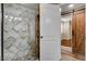Beautifully tiled shower, glass enclosure, with a view of another bedroom with wood floors at 516 Arizona St, Boulder City, NV 89005