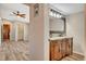 Bathroom featuring a double sink vanity with decorative wood trim, ceiling fan, and adjacent bedroom at 516 Arizona St, Boulder City, NV 89005