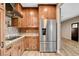 Well-equipped kitchen with stainless refrigerator, cooktop, and brick backsplash detail at 516 Arizona St, Boulder City, NV 89005