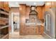 Modern kitchen with stainless steel appliances, wood cabinets, and adjacent laundry area at 516 Arizona St, Boulder City, NV 89005