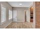 Open-concept room with wood-look flooring and brick accent wall at 516 Arizona St, Boulder City, NV 89005