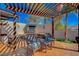 Backyard area featuring a pergola-covered seating area with a built-in fireplace, desert landscaping, and stone accents at 516 Arizona St, Boulder City, NV 89005