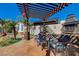 Backyard lounge area under a pergola with stylish seating, a stone fireplace, and desert landscaping at 516 Arizona St, Boulder City, NV 89005
