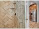 Updated shower with herringbone tile, glass enclosure, and a view into the kitchen at 516 Arizona St, Boulder City, NV 89005