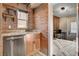 Charming wet bar featuring brick accent wall, granite countertops, stainless steel dishwasher, and wooden shelves at 516 Arizona St, Boulder City, NV 89005
