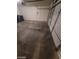 View of inside the garage with an open garage door, concrete floor, and black trash bins at 5316 Clover Blossom Ct, North Las Vegas, NV 89031