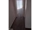 Narrow hallway with carpet floors leading towards a sunlit room in the distance at 5316 Clover Blossom Ct, North Las Vegas, NV 89031