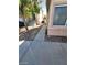 View of side yard with walkway and partial view of house windows and neighboring staircase entrance at 5316 Clover Blossom Ct, North Las Vegas, NV 89031