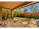 Inviting backyard with brick patio, lush landscaping, and green lawn at 5662 Escamilla Rd, Las Vegas, NV 89135