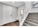 Inviting entryway featuring hardwood floors, staircase, and a modern chair for a welcoming atmosphere at 5662 Escamilla Rd, Las Vegas, NV 89135