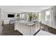 Bright open-concept kitchen and living room with a large island, modern lighting, and natural light at 5662 Escamilla Rd, Las Vegas, NV 89135