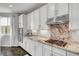 Modern kitchen with stainless steel appliances, granite countertops, white cabinets and hardwood floors at 5662 Escamilla Rd, Las Vegas, NV 89135