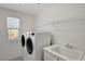 Bright laundry room with washer, dryer, sink and overhead storage shelf at 5662 Escamilla Rd, Las Vegas, NV 89135
