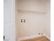 Bright laundry room features wooden floor, wall-mounted shelf, and modern water hookups at 5828 Red Gull St, Las Vegas, NV 89149