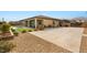 Rear exterior view of single-story home features gravel landscaping and elongated driveway at 5860 Noah Springs Ct, Las Vegas, NV 89149