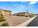 Spacious three-car garage with brick-paved driveway and desert landscaping at 5860 Noah Springs Ct, Las Vegas, NV 89149