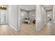 Hallway leading to office with modern desk and chair, with wood-look floors and white trim at 5860 Noah Springs Ct, Las Vegas, NV 89149