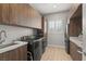 Laundry room with sink, wood cabinets, washer, and dryer at 5860 Noah Springs Ct, Las Vegas, NV 89149