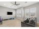 Bright, open living room with wood-look floors, grey walls and furniture, and large windows with shutters at 5860 Noah Springs Ct, Las Vegas, NV 89149