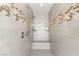 A shower featuring a built-in bench, handheld shower head, and tiled surround with decorative accent at 5860 Noah Springs Ct, Las Vegas, NV 89149