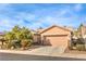 Charming single-story home with a well-maintained front yard, a two car garage and a desert landscaped yard at 6128 Forest Pony Ave, Las Vegas, NV 89122