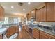 Open-concept kitchen with wooden cabinetry, stainless steel appliances, and wood flooring at 6128 Forest Pony Ave, Las Vegas, NV 89122