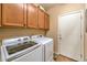Cozy laundry room with side-by-side washer and dryer and overhead cabinetry for storage at 6128 Forest Pony Ave, Las Vegas, NV 89122