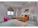 Bright bedroom featuring a charming design with a twin bed and a pink chair at 6265 Iron Mountain Rd, Las Vegas, NV 89131