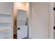 Compact laundry room with stacked washer and dryer and storage shelves at 6265 Iron Mountain Rd, Las Vegas, NV 89131