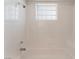 White tiled bathtub/shower with a window and grab bars for safety at 6808 Elm Creek Dr # 203, Las Vegas, NV 89108