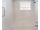 White tiled bathtub/shower with a window and grab bars for accessibility at 6808 Elm Creek Dr # 203, Las Vegas, NV 89108