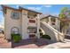Exterior of a condo with red rock landscaping, stucco walls, and terracotta roof tiles at 6808 Elm Creek Dr # 203, Las Vegas, NV 89108
