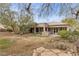 Expansive backyard featuring desert landscaping, a covered patio, and mature shade trees at 7288 Olsen Farm St, Las Vegas, NV 89131