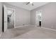 Spacious carpeted bedroom with an adjacent bathroom, hallway, and neutral colors at 7288 Olsen Farm St, Las Vegas, NV 89131