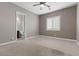 Neutral bedroom with tan carpet, ceiling fan, and an attached bathroom at 7288 Olsen Farm St, Las Vegas, NV 89131